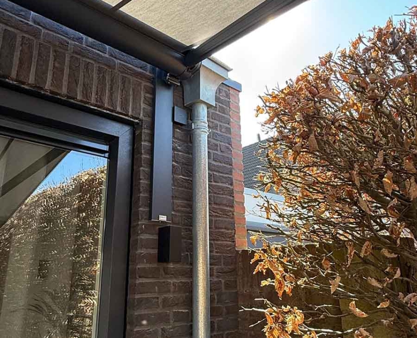 Montage van zonnescherm aan uitbouw