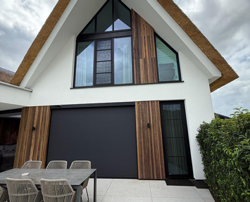 Draadloze Heroal screens met Somfy Solar RS100 IO technologie geïntegreerd in het strakke gevelontwerp van een eigentijdse woning.